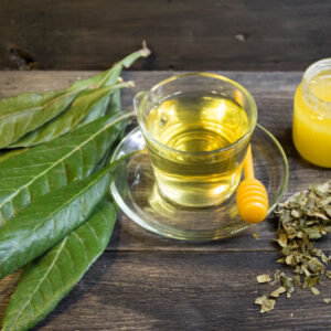 medicinal infusion of loquat leaves with honey, on rustic wooden background