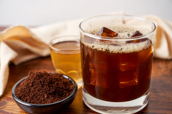 Popular cocktail called carajillo made with espresso, liquor and ice on a wooden table.