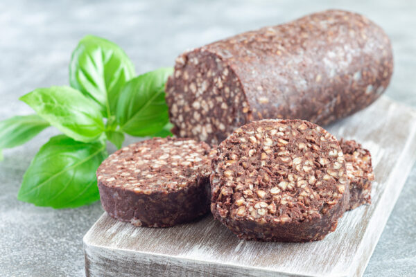 Traditional Irish and British black pudding sausage slices on a wooden board, horizontal